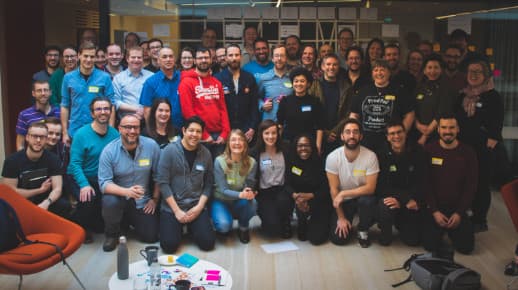 Group photo showing 5 rows of happy people smiling into the camera.